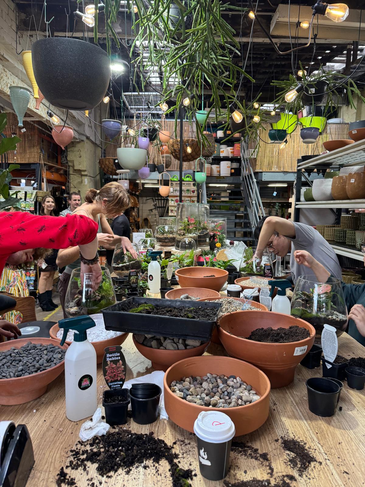 Terrarium workshop attendees layering substrate at Newtown Garden Market